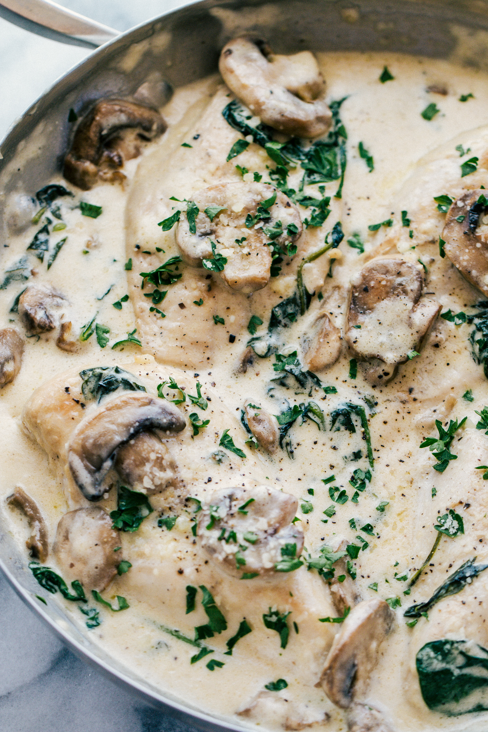 chicken skillet recipe cooked in a garlic cream sauce with mushrooms and spinach, by The Food Cafe. 