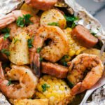 shrimp, corn, sausage, and potatoes cooked in foil with a fork for serving.