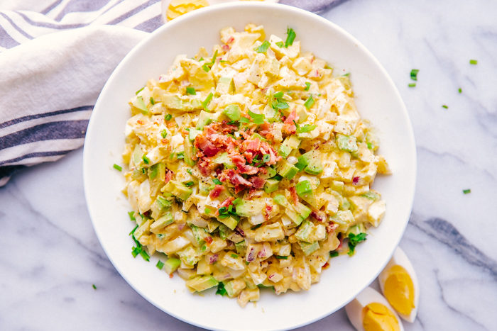 Curried Egg Salad in a white bowl with bacon crumbles on top