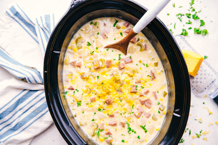 Cheesy Ham and Potato Soup in crock pot topped with cheese