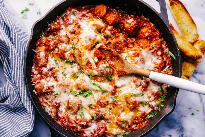 cheesy skillet meatballs being served with garlic toast. 
