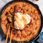 pumpkin cobbler in a skillet with ice cream and 2 spoons