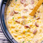 Slow Cooker Creamy Sausage and Potato Soup Recipe being stirred with a spoon.