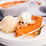 a slice of easy healthy crustless pumpkin pie on a plate with ice cream and whipped topping.